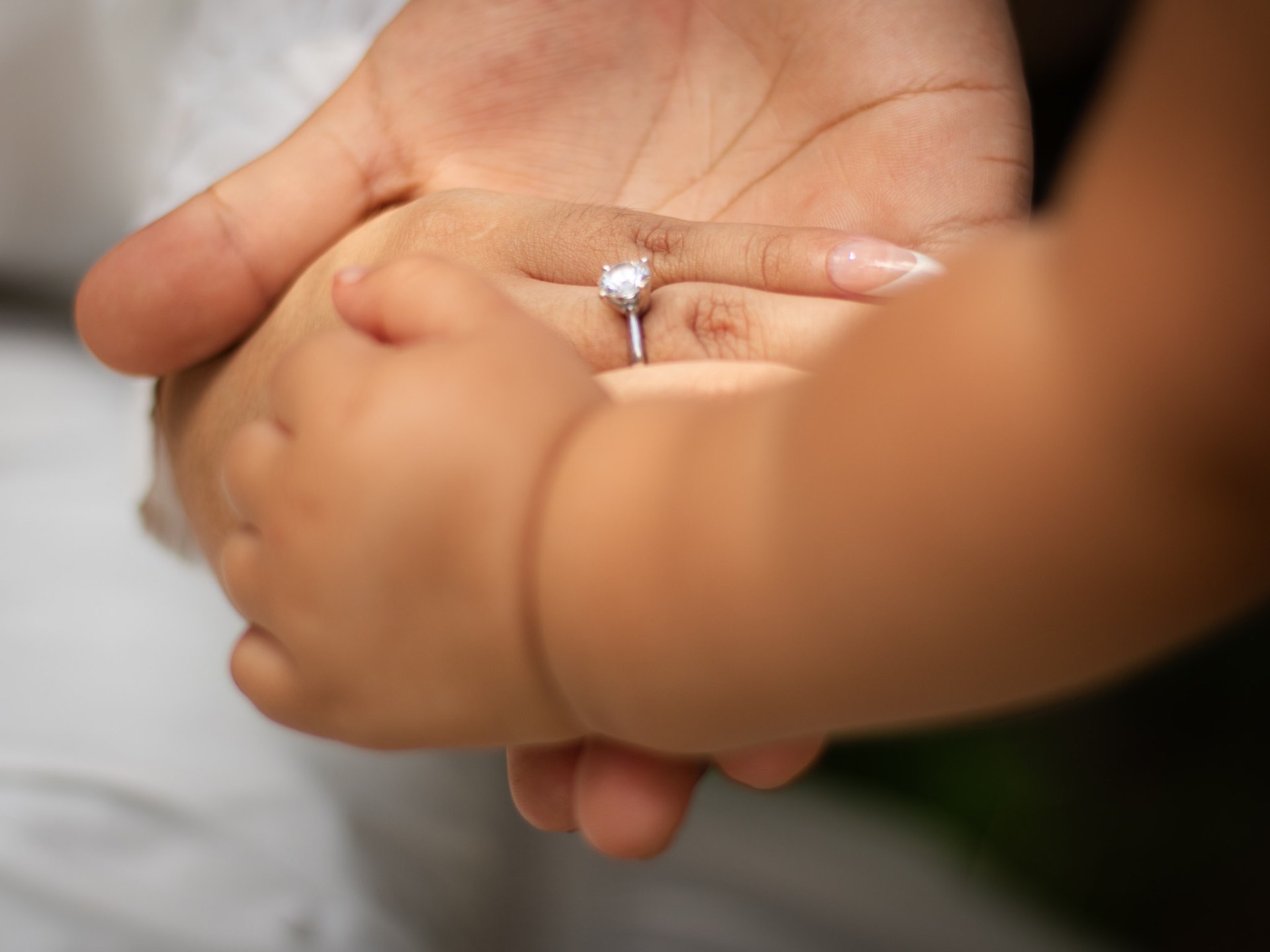 Close-up of engagement ring resting on partner's palm